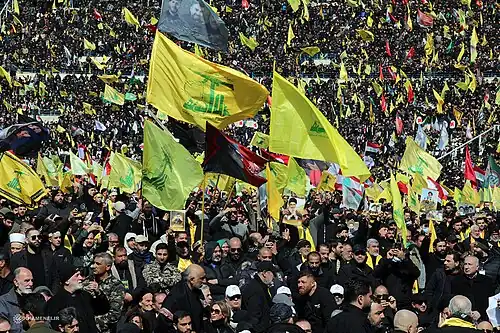 Thousands of people waving Hezbollah flags