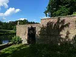 Brick wall with doorway and ornamental urn