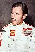 Graham Hill in a racing suit looking to the right of the camera