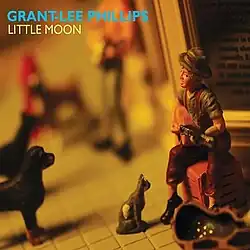 Figurines of a busker surrounded by animals listening to him play on a sidewalk