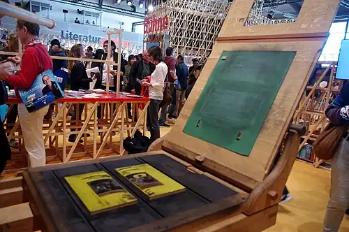 Replica of the Gutenberg press. The platen on the right holds the paper, and is pressed down onto the typeset.