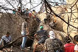 Enthusiasts crowd a rock formation