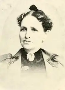 A younger white woman, wearing a portrait brooch at her throat.