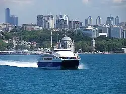 A catamaran Seabus on the Bosphorus, with the skyscrapers of Levent business district in the background. Istanbul Sapphire is the first skyscraper on the left.