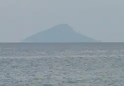 The island photographed from a great distance, which results in the image only revealing the island's outline.