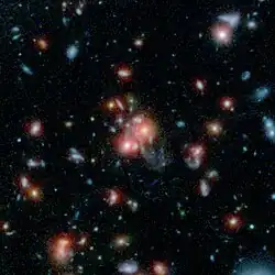 Galaxy cluster SpARCS1049 taken by Spitzer and the Hubble Space Telescope.[31]