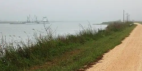 A barge on the Intracoastal Waterway passing McFaddin National Wildlife Refuge