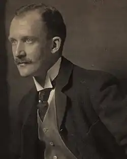 A sepia toned photo of a man looking off left.