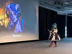 Jester Lavore cosplayer in front of an image of Molly