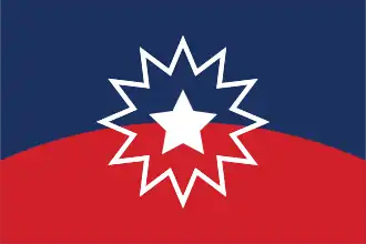 A large street festival in Milwaukee, Wisconsin. Much of the crowd is African American, and cooking smoke can be seen rising from food trucks and stands parallel to the street.