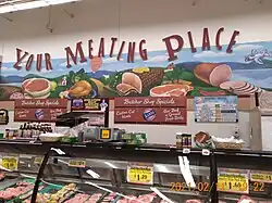 A display of Karns' meat selection, titled "Your Meating Place". With plenty of fresh cut meat products in a display case.