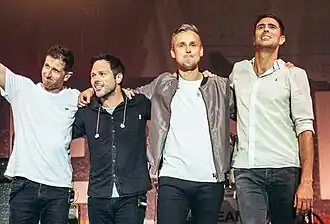 Keane standing side-by-side onstage