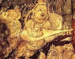 India, in Ajanta Caves, Cave 1, c. 450-490 AD. Kinnara with "kacchapī veena" (Sanskrit for "tortise veena") or panchangi veena (5-stringed veena). Part of the painting Bodhisattva Padmapani.[135][136][note 2]