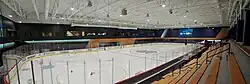 Panoramic view of an indoor ice hockey rink with a Seattle Kraken logo at the center