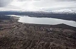 Aerial photo of a long Lake Clark with snowy mountains behind it