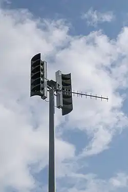 A large pole with two sets of loudspeaker horns mounted opposite each other at the top.
