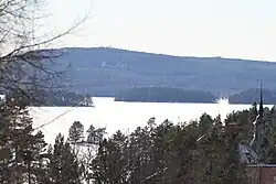 Åmänningen is covered in snow and ice. Villa Ulvaklev is in the foreground in the lower right corner. Landsberget is visible in the background. The picture is taken from Ängelsberg.