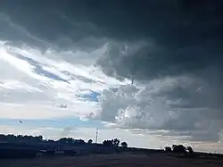 Photograph of a landspout under mostly cloudy skies