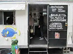 A hand-lettered menu advertises pastelillos, bacalaito, guineito