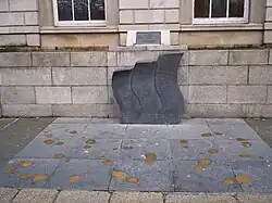 three gray curved stones memorial on sidewalk