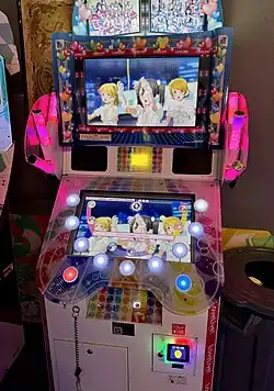 The PlayStation 4 version cover art features the title logo, which reads "Love Live! School Idol Festival: After School Activity Wai-Wai! Home Meeting!!". The cover art also features two characters: on the left is Honoka Kōsaka wearing "Sakura Paint Memories" costume, and on the right is Chika Takami wearing "Marine Paint Memories" costume.