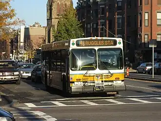 A white and yellow transit bus on an urban street
