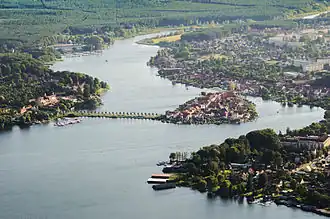 A body of water surrounded by greenery and human settlements.