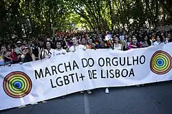 Crowd in a street, with the organizers' banner