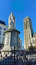 Statue of 1849 in the market square of Mechelen, St. Rumbold's Cathedral behind