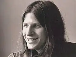 Twentysomething with big smile and long hair