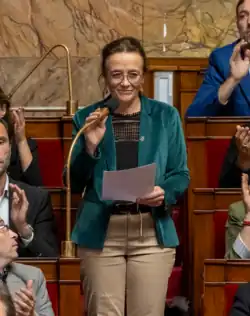 Mathilde Feld standing in front of a microphone at the National Assembly