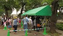 People standing near a green tent