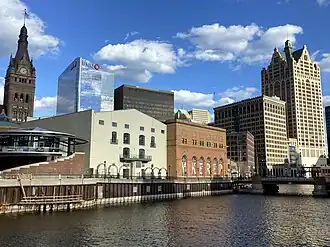 Downtown Milwaukee from the Milwaukee River. Back, left to right: City Hall, BMO Tower, Marshall & Ilsley Bank Building, AT&T Center, and 411 East Wisconsin Center. Front, left to right: Repertory Theater, Manufacturers' Home Building, First National Bank Building, and 100 East Wisconsin.
