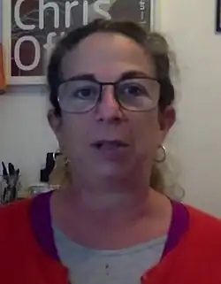 Headshot of Roffey, who wears glasses, in an indoors environment