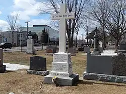 A white marble cross on a cemetery