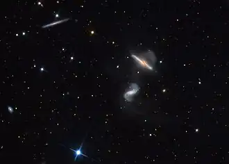 An uncropped version of the image showing the interacting galaxies and UGC 10641, a flat galaxy at the top left area.