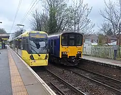 A tram-train on rail, along with a heavy rail train