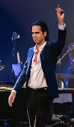 Nick Cave performing to the side of the camera
