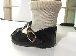 Velcro straps on a pair of Mary Jane shoes worn by an American Girl doll; the buckles used on the straps are purely for aesthetic purposes.