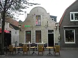 Small gable to gable building in yellow brick with details in red stone, dated 1722, on the island of Terschelling in the Netherlands
