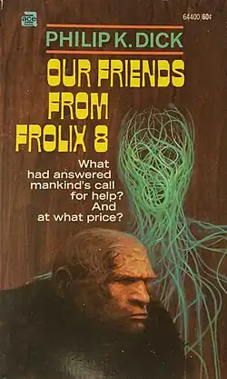 A man-shaped alien figure made of green lines stands behind a bald man