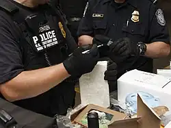 United States CBP police inspect a seized shipment of cocaine.