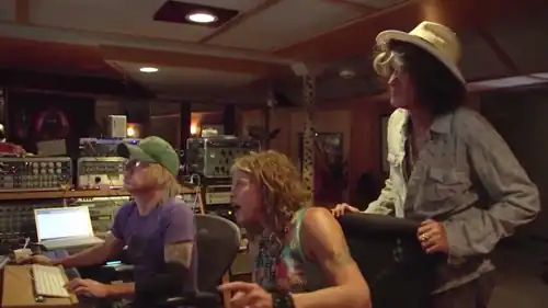 Sound engineer for Aerosmith sitting in the recording studio at the mixing board with Steven Tyler and Joe Perry of Aerosmith.