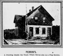 old two-story building the size of a small house near railroad tracks
