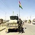 Peshmerga soldier standing in front of a Humvee.