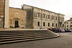 View of Piazza San Pietro with the church facade on the right and steps leading up.