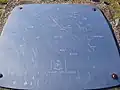 Plaque pointing out the directions of landmarks and their distances from the summit