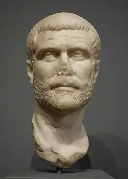 Marble portrait head of a man with short hair and a short curly beard and mustache, looking slightly upward to the right