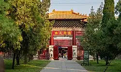 An entrance to a temple with red door and yellow roof