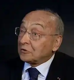 Glanced view of a balding caucasian male wearing spectacles and a suit